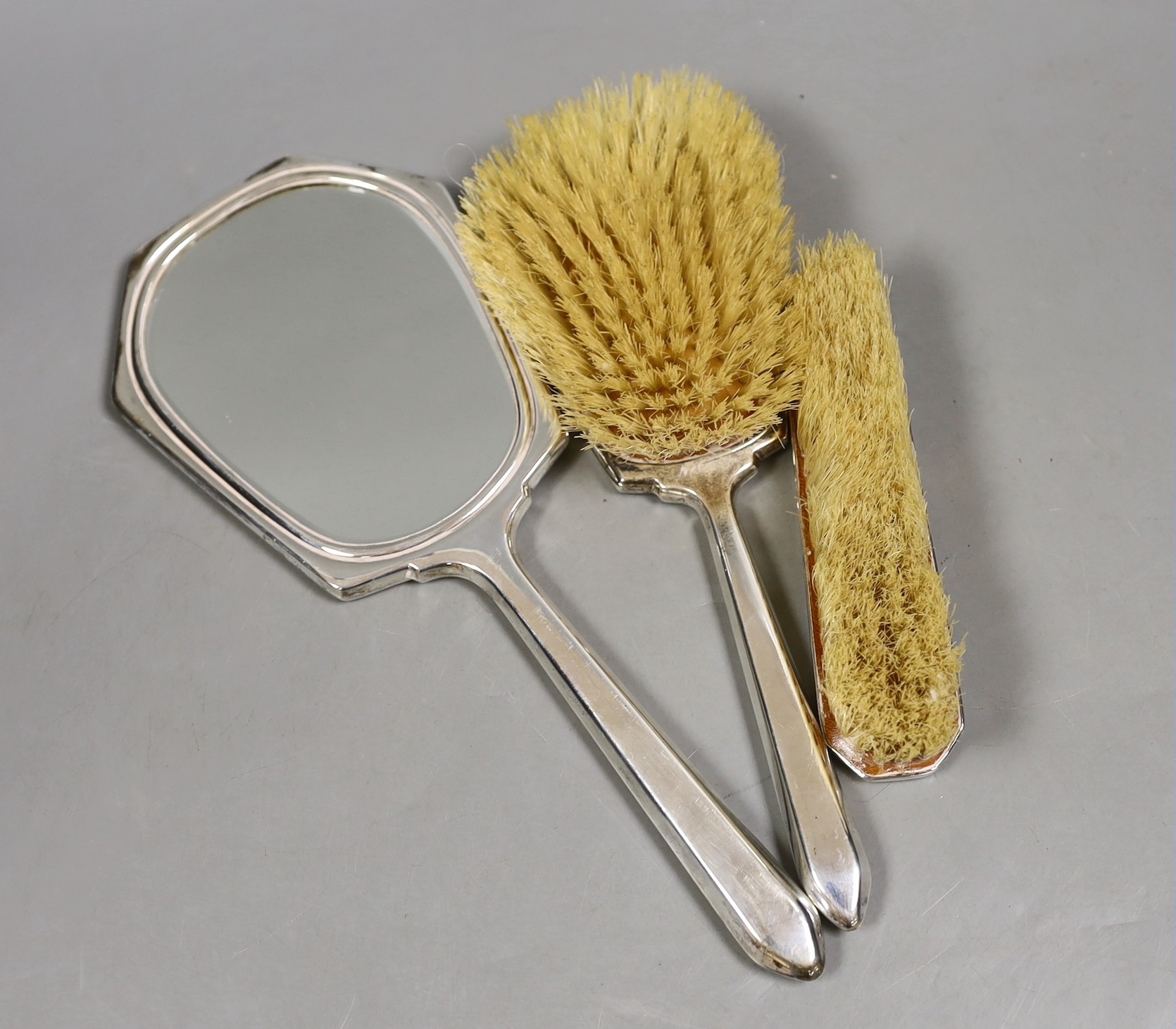 A George VI silver and green guilloche enamel three piece mirror and brush set, Daniel Manufacturing Co. Birmingham, 1938/9, mirror 27cm.